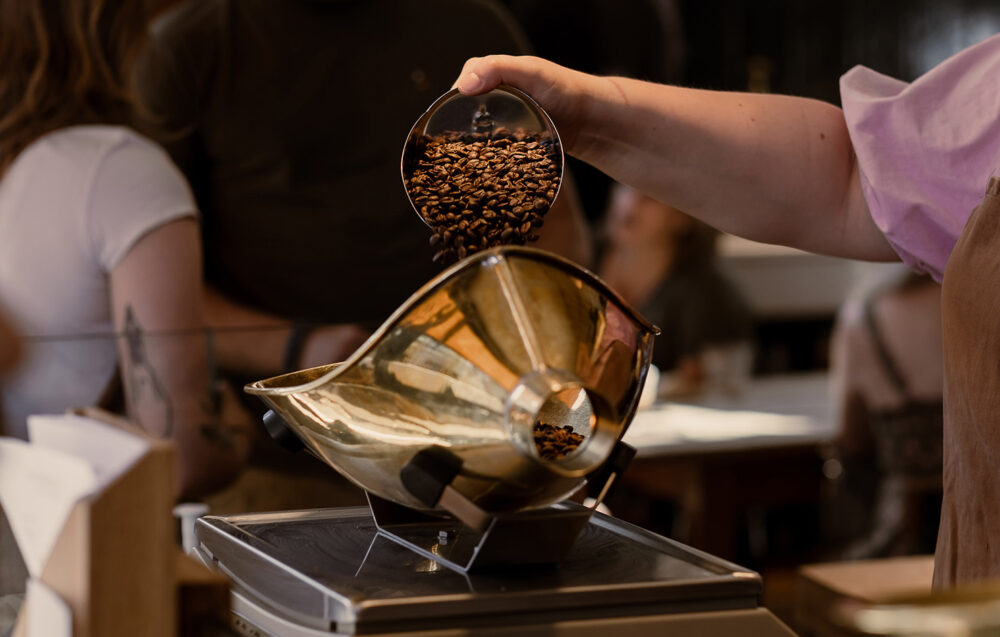 A Retailer-Barista weighing out coffee beans in one of our shops